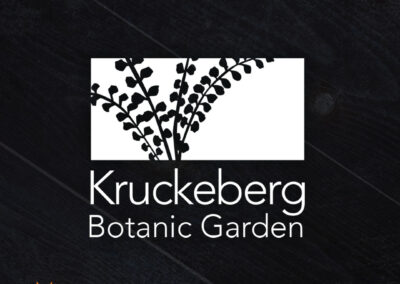 A bold and vibrant logo for Kruckeberg Botanic Garden featuring a stylized plant in the box with the words Kruckeberg Botanic Garden below.